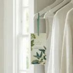 クローゼットに掛けたAshleigh & Burwoodのサシェ。白い衣類のそばに香りのサシェを吊るした使用イメージ。